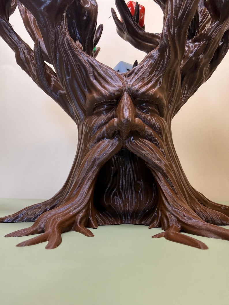 Pu&ograve; includere: Scultura a forma di albero marrone stampata in 3D con un volto scolpito nel tronco. La scultura presenta una superficie dettagliata e strutturata, con il volto caratterizzato da un naso e una barba prominenti. I rami dell'albero si estendono verso l'alto.