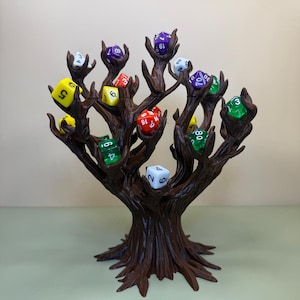 Pu&ograve; includere: Un porta dadi a forma di albero marrone con pi&ugrave; rami, ognuno dei quali tiene un dado a pi&ugrave; facce. I dadi sono di vari colori, tra cui giallo, verde, rosso e viola. Il supporto &egrave; progettato per esporre e conservare i dadi.