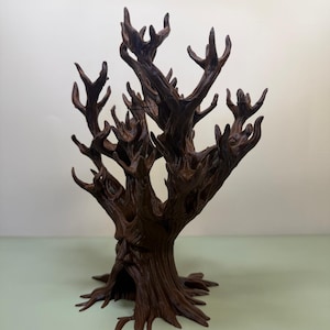 Pu&ograve; includere: Una scultura di albero marrone scuro stilizzata con un volto scolpito nel tronco. L'albero ha molti rami e una superficie strutturata dettagliata. La scultura &egrave; un oggetto decorativo.