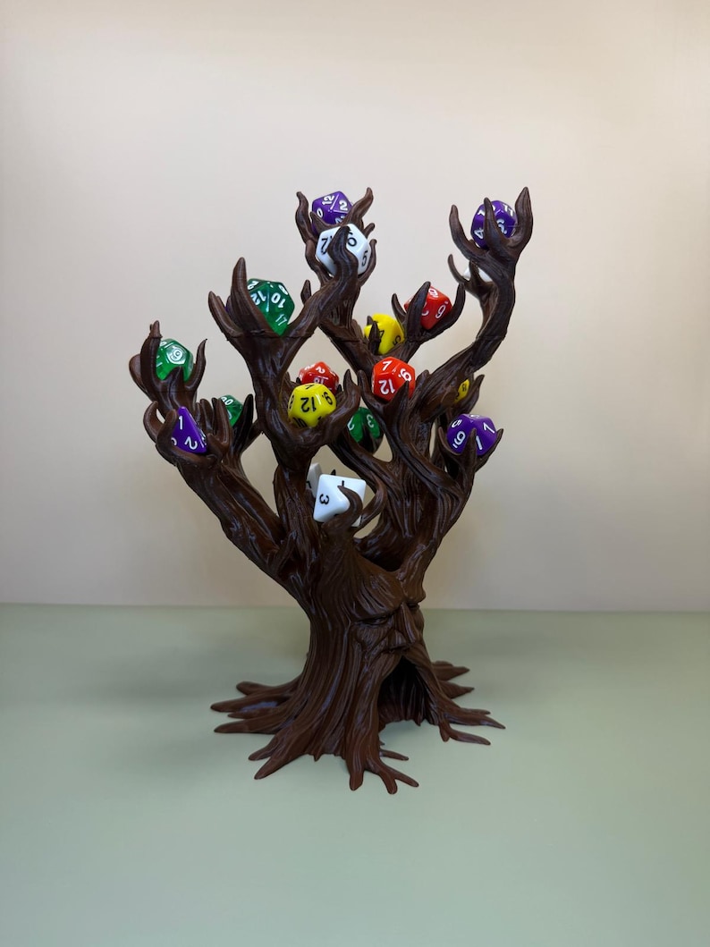 Pu&ograve; includere: Un porta dadi a forma di albero marrone, con pi&ugrave; rami, ognuno dei quali tiene un dado di colore diverso. I dadi sono di vari colori, tra cui verde, rosso, viola e giallo. Il supporto &egrave; progettato per assomigliare a un tronco e ai rami di un albero.