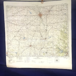May include: A vintage map of the United States, showing the state of Kansas. The map is printed on a cream-colored paper and features a grid system with black lines. The map includes various geographical features, such as rivers, lakes, and roads. The map is titled "Topographic Map" and has a scale of 1:250,000.