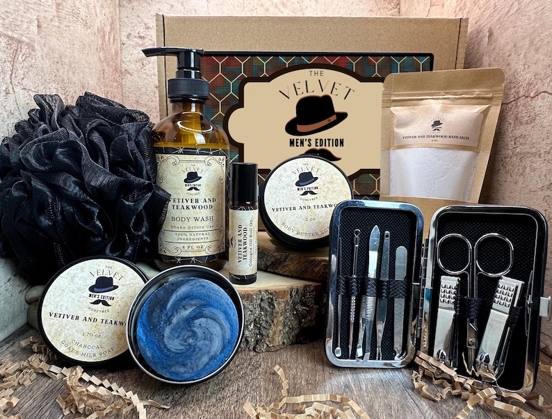 Puede incluir: Un set de regalo para hombres que incluye una caja marr&oacute;n con un patr&oacute;n de cuadros negros y rojos. La caja contiene una botella de vidrio transparente de gel de ducha, una peque&ntilde;a botella de manteca corporal, una barra de jab&oacute;n, una toallita negra, un juego de manicura plateado y una bolsa de sales de ba&ntilde;o. Los productos est&aacute;n etiquetados con el texto "The Velvet Men's Edition" y "Vetiver and Teakwood".