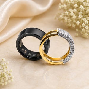 May include: A black ceramic band ring positioned next to a gold band ring featuring a pavé setting of small clear stones along the outer surface. The black ring has a smooth, glossy finish, while the gold ring displays a polished metallic luster.