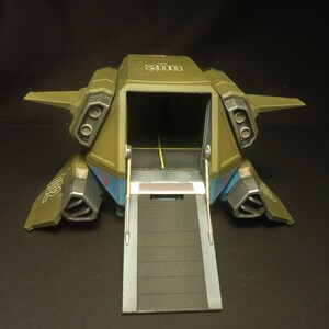 Puede incluir: Un veh&iacute;culo de transporte de juguete de estilo militar en verde oliva, azul y gris. El veh&iacute;culo tiene una bah&iacute;a de carga abierta con una rampa extendida. La parte superior del veh&iacute;culo tiene el n&uacute;mero "200" impreso. Tiene puertos de escape dobles.