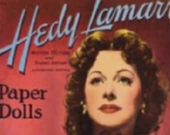 Op de afbeelding: Vintage filmposter voor "Paper Dolls" met Hedy Lamarr. De poster heeft een rode achtergrond met de titel in grote, gestileerde tekst. Lamarr wordt afgebeeld met donker krullend haar, rode lippenstift en een decoratieve waaier.
