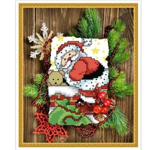 May include: A cross-stitch pattern of Father Christmas climbing down a chimney with a teddy bear in his arms. The pattern is framed with a gold frame and surrounded by green pine branches, red berries, and gold beads.