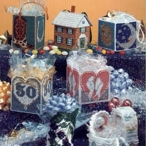 May include: A collection of six handmade plastic canvas gift bags. The bags are decorated with various themes, including a cowboy boot, a house, a sun and moon, a heart with the number 50, two doves, and a floral design. The bags are filled with clear plastic filler and jelly beans.