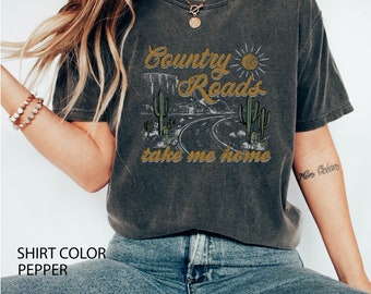 May include: A gray t-shirt with a vintage-style graphic of a desert road with cacti and the text "Country Roads take me home".