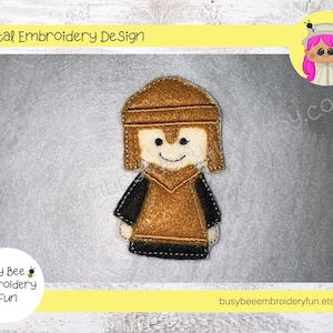 May include: Embroidered felt applique of a brown-haired person wearing a brown helmet and a brown tunic. The person is smiling and has a black outline.