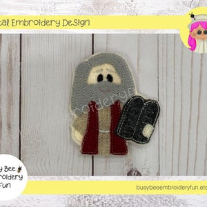 May include: Digital embroidery design of a grey-haired man wearing a red robe and holding a grey stone tablet. The design is ideal for creating a religious-themed craft project.