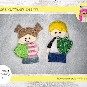 Könnte beinhalten: Zwei Filz-Fingerpuppen, ein Junge und ein Mädchen, die jeweils einen grünen Schild mit dem Buchstaben "OK" darauf halten. Die Puppen lächeln und haben braunes Haar. Der Hintergrund ist eine weiße Holzmaserung.