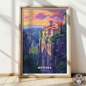 May include: Framed art print of Meteora, Greece, featuring a vibrant sunset over a cliffside monastery. The artwork showcases a detailed illustration of the buildings, cliffs, and surrounding landscape, with the text "METEORA GREECE" at the bottom.
