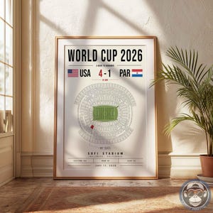 May include: A framed poster titled WORLD CUP 2026 A NIGHT TO REMEMBER featuring a stadium diagram, the score USA 4-1 PAR, and text indicating SOFI STADIUM, INGLEWOOD, CALIFORNIA, SECTION 123, ROW 14, SEAT 22, and the date JUNE 12, 2026.