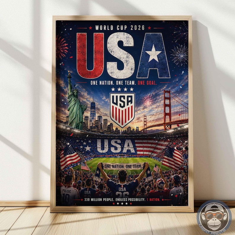 May include: A framed poster for World Cup 2026 featuring the text USA, One Nation. One Team. One Goal. The image displays the Statue of Liberty, the Golden Gate Bridge, a soccer stadium, a USA crest, and a crowd holding a banner with the same text.