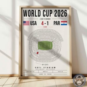 May include: A framed poster titled WORLD CUP 2026 featuring a stadium seating chart for SoFi Stadium in Inglewood, California. The graphic displays a 4-1 score between USA and PAR, with a red highlighted seat marked as MY SEATS, section 123, row 14, seat 22.