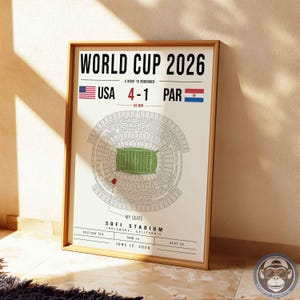 May include: A framed poster titled WORLD CUP 2026 featuring a stadium seating chart, the score USA 4-1 PAR, and the text SOFI STADIUM, INGLEWOOD, CALIFORNIA, SECTION 123, ROW 14, SEAT 22, JUNE 12, 2026, with a red seat highlighted on the diagram.