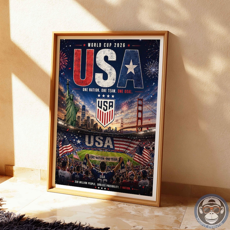 May include: A framed poster for the World Cup 2026 featuring the text USA, the Statue of Liberty, the Golden Gate Bridge, a soccer stadium, American flags, and the phrase One Nation. One Team. One Goal. The design includes fireworks and a crowd.