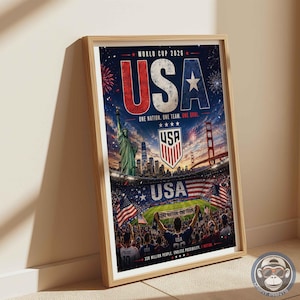 May include: A framed poster for the World Cup 2026 featuring the text USA, the Statue of Liberty, the Golden Gate Bridge, a soccer stadium filled with fans, the US soccer crest, and the text One Nation. One Team. One Goal. 330 Million People.