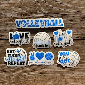 May include: A set of nine volleyball-themed stickers with various designs and slogans, including "Love Volleyball", "Volleyball Junkie", "Eat Sleep Volleyball Repeat", "Peace Love Volleyball", "You Just Got Served", and "Live Love Volleyball".
