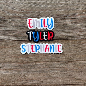 May include: Three personalized name stickers with white backgrounds and colorful lettering. The names are "Emily", "Tyler", and "Stephanie".