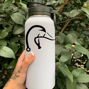 K&ouml;nnte beinhalten: Wei&szlig;e Wasserflasche mit einem schwarzen Enten- und Geweihdesign. Die Flasche hat einen schwarzen Deckel mit einer Schlaufe.