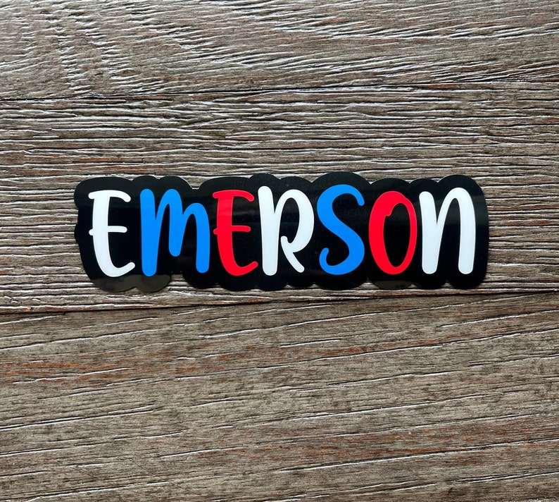May include: Black vinyl sticker with the name "EMERSON" in white letters with blue and red accents.