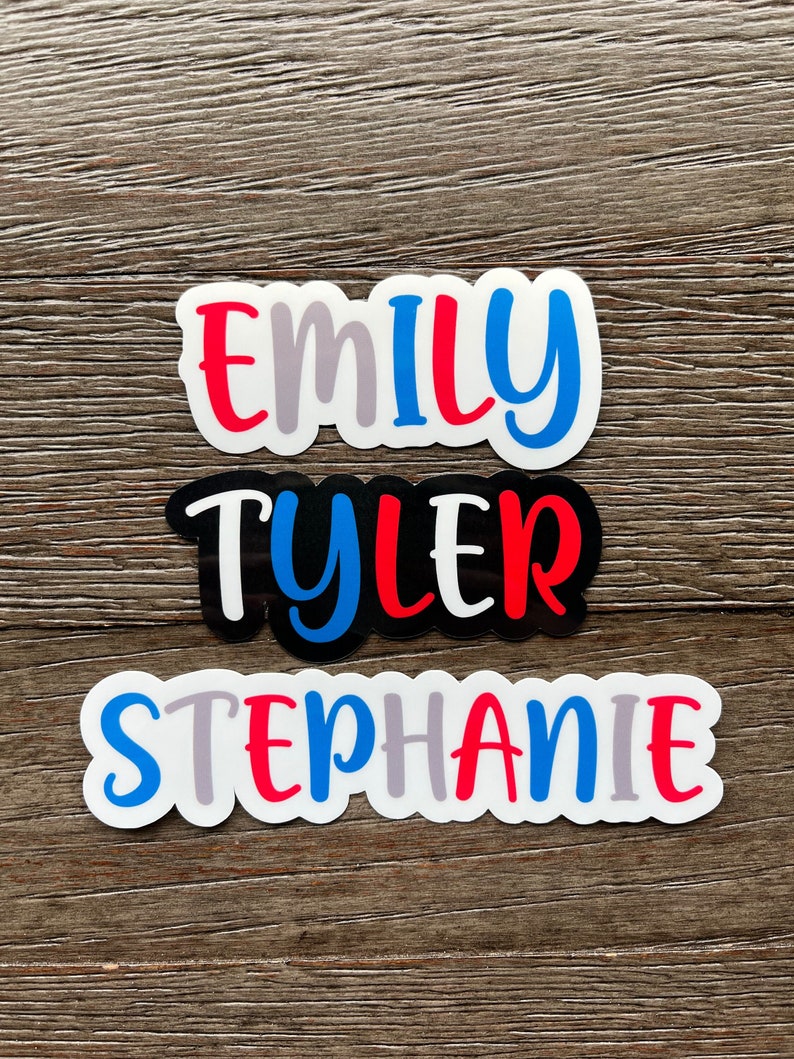 May include: Three personalized name stickers with white backgrounds and colorful lettering. The names are "Emily", "Tyler", and "Stephanie".