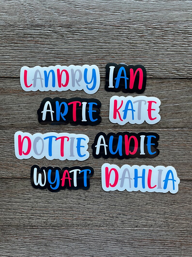 May include: Eight colorful name stickers with white backgrounds. The names are Landry, Ian, Artie, Kate, Dottie, Audie, Wyatt, and Dahlia.