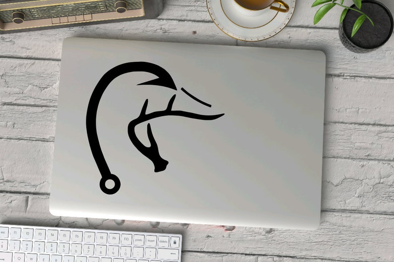 K&ouml;nnte beinhalten: Ein schwarz-wei&szlig;er Aufkleber mit einem Entenkopf mit Geweih auf einem silbernen Laptop.