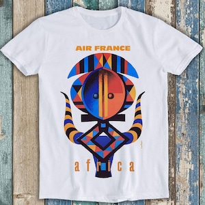Peut inclure: T-shirt blanc avec un motif graphique coloré d'un masque africain avec le texte "AIR FRANCE" et "africa" imprimé dessus.