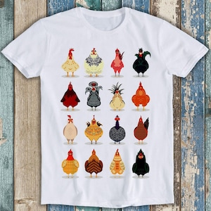 May include: A white short-sleeve t-shirt featuring a graphic print of sixteen different chickens arranged in a four-by-four grid. Each chicken is illustrated in a distinct color, pattern, and style, showcasing a variety of poultry breeds.