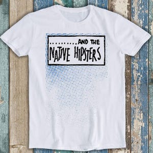 May include: White t-shirt with a blue and white halftone pattern and black text that reads "... ... AND THE NATIVE HIPSTERS"