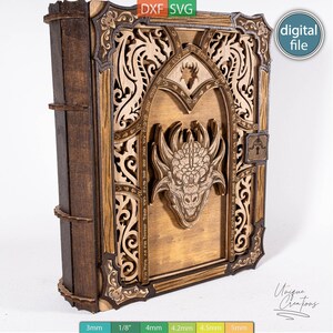 Può includere: Una copertina per libro in legno multistrato con una testa di drago tagliata al laser al centro, circondata da volute ornate e motivi di draghi. Il design include un dettaglio a forma di serratura e testo lungo l'arco, con un dorso marrone scuro.