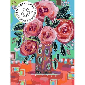 May include: A paint-by-number kit featuring a vibrant floral arrangement in a patterned vase. The artwork displays stylized pink and red roses with dark green leaves against a light blue background, set upon a textured orange surface with rectangular accents.