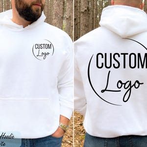 A man wearing a white hoodie with the text "CUSTOM Logo" printed on the back.