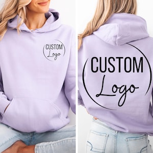 A woman wearing a purple hoodie with the text "CUSTOM Logo" printed on it.