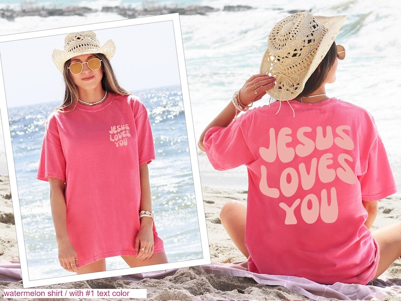 a woman sitting on the beach wearing a pink jesus loves you t - shirt