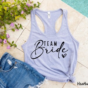 May include: A heather gray tank top with the text "Team Bride" in black script lettering and a small heart.