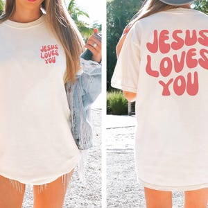 a woman wearing a jesus loves you t - shirt