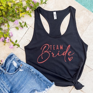 May include: Black tank top with a racerback style and the text "Team Bride" in red script with a small red heart.