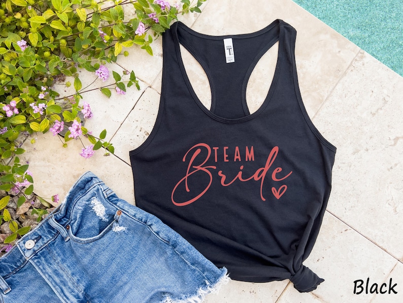 May include: Black tank top with a racerback style and the text "Team Bride" in red script with a small red heart.
