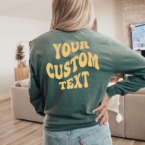 Może przedstawiać: Zielony, dług rękawowy t-shirt z napisem "YOUR CUSTOM TEXT" w kolorze ż&oacute;łtym na plecach.