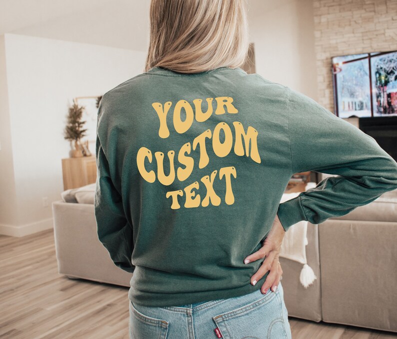 Może przedstawiać: Zielony, dług rękawowy t-shirt z napisem "YOUR CUSTOM TEXT" w kolorze ż&oacute;łtym na plecach.