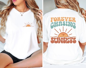 May include: White t-shirt with a small sunset graphic on the front and the text "FOREVER CHASING SUNSETS" in a retro font on the back.