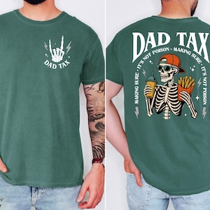 A man wearing a green t-shirt with a graphic design on the back. The design features a skeleton holding a beer and the text "DAD TAX" above it.