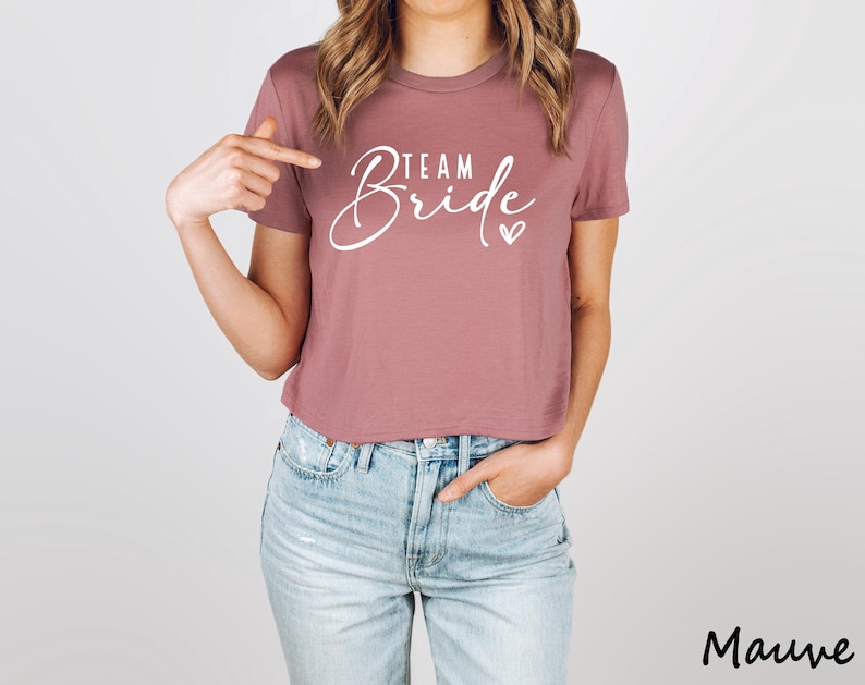 May include: Mauve cropped t-shirt with the text "Team Bride" in white lettering and a small heart.