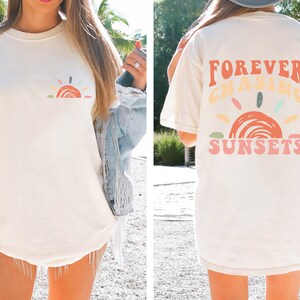 May include: A white t-shirt with a colourful sunset graphic and the text "FOREVER CHASING SUNSETS" on the back.