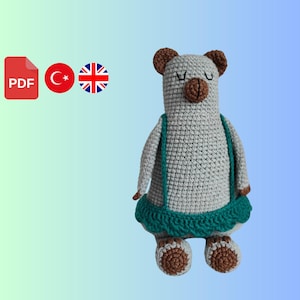 Puede incluir: Patrón de crochet para un oso gris y verde con pies marrones. El patrón está disponible en inglés y turco.