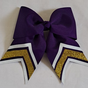 May include: Purple cheer bow with white and gold glitter chevron accents.