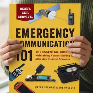 May include: A yellow book titled "Emergency Communication 101" with the text "Ready. Set. Survive." in a red box. The cover features illustrations of a satellite, radio, and walkie-talkies. The book is held by a person wearing a green sweater.